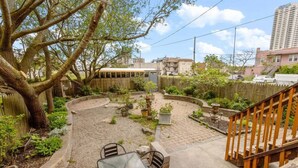 A courtyard with a table and chairs, surrounded by trees and potted plants. - Unique 5BD/3BA near Hard Rock, Ocean & Boardwalk (Atlantic City)