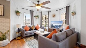 A modern living room with a grey sofa set, a coffee table, and a ceiling fan. - Unique 5BD/3BA near Hard Rock, Ocean & Boardwalk (Atlantic City)