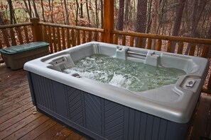 A hot tub on a wooden deck with a wooden fence in the background. - Whispering Pines - Cozy, Log Cabin - Hocking Hills (Logan)