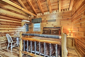 A log cabin interior with a wooden bed, a desk, a chair, and a window. - Whispering Pines - Cozy, Log Cabin - Hocking Hills (Logan)