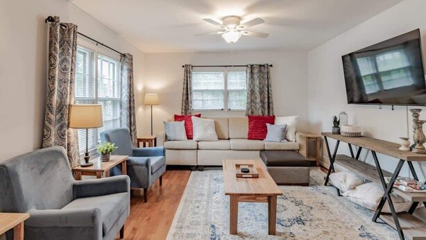 A living room with a sofa, armchairs, a coffee table, and a TV. - Near Midtown, Highways, Downtown! Bel-Air Bungalow (Mobile)