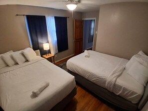 A hotel room with two single beds, a nightstand with a lamp, and a window with curtains. - Near Midtown, Highways, Downtown! Bel-Air Bungalow (Mobile)