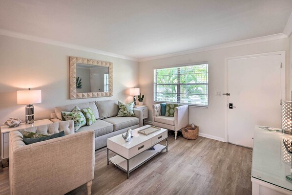 A living room with a beige sofa, a white coffee table, and a glass cabinet.