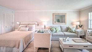 A bedroom with two beds, a sofa, a coffee table, and a bedside table with a lamp. - Renovated Studio at Naples Beach & Town! (Naples)