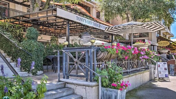 Un restaurant appelé « TONY’S OFF THIRD WINE », doté d’une terrasse, d’un escalier et d’une enseigne indiquant « RIDGWAY ».