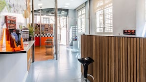 A modern interior with a reception desk, a digital clock, and a city map on the wall. - Hostel Center Madrid (Madrid)