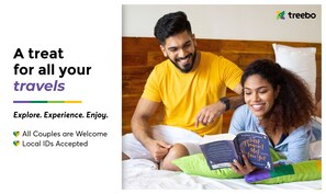 Una pareja leyendo un libro en una cama con cabecera de madera.