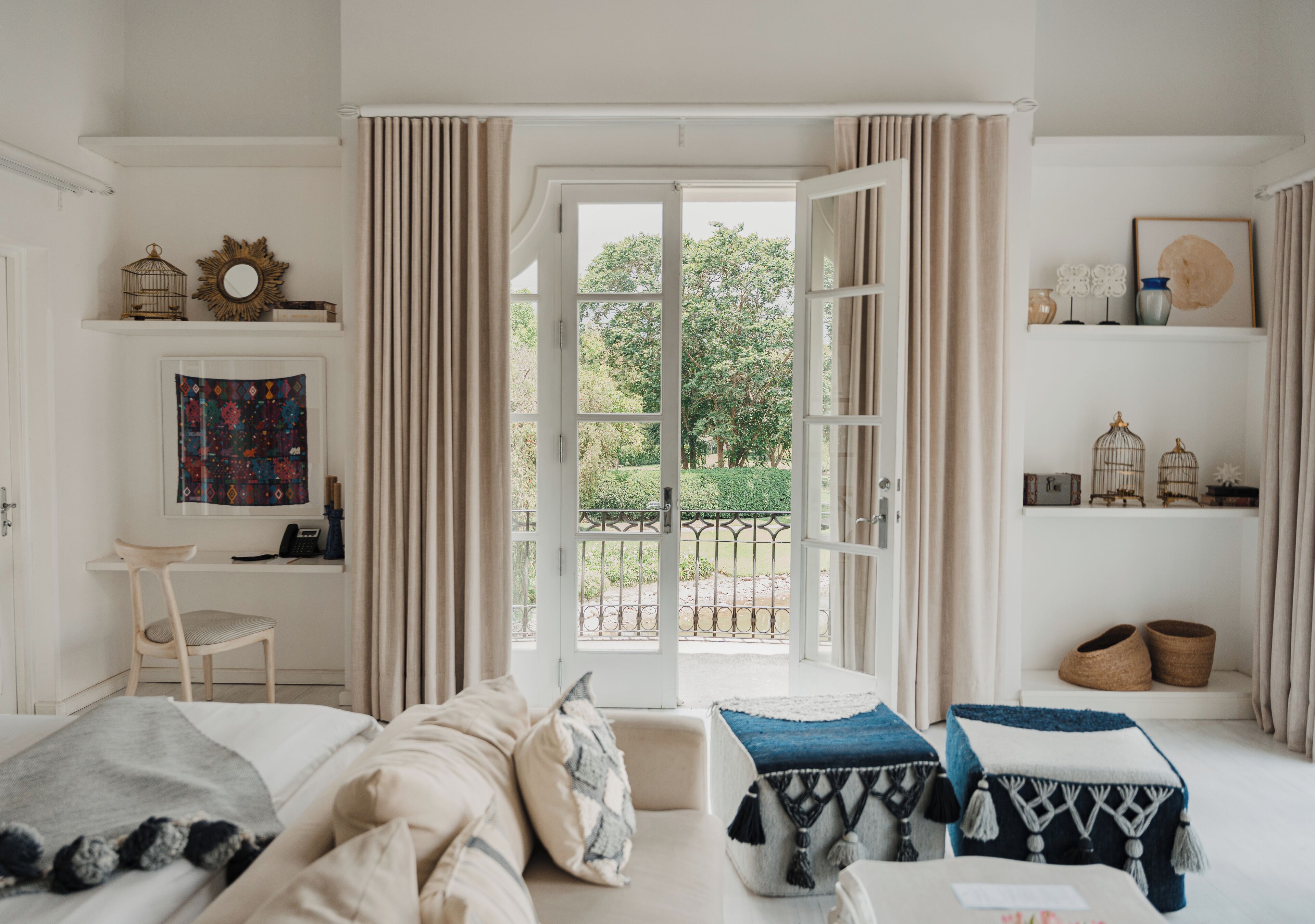 Une chambre à coucher avec un lit, un bureau et une vue sur l’extérieur.