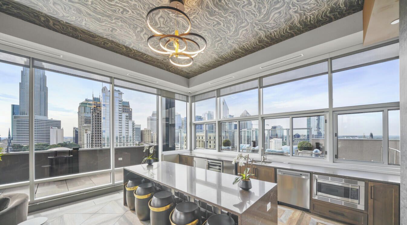 A modern kitchen with large windows, a central island, and a city view.