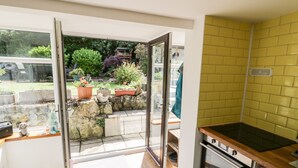 A kitchen with an open door leading to a garden.