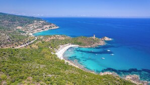 An aerial view of a coastal area with a winding road, a beach, and boats in the water. - Superb Villa with pool, sea & maquis views. Terrace 400m from the beach! (Sainte Lucie de Porto-Vecchio)