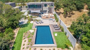 A modern house with a swimming pool, deck, and outdoor seating area surrounded by trees. - Superb Villa with pool, sea & maquis views. Terrace 400m from the beach! (Sainte Lucie de Porto-Vecchio)