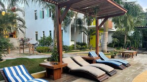 A poolside area with sun loungers and a pergola.