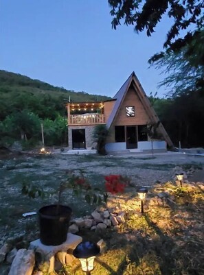 Escape to a serene cabin-style retreat surrounded by lush greenery and a charming garden.