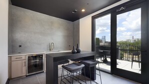 Une cuisine moderne dotée d’une grande fenêtre, d’un four encastré et d’un coin bar avec des tabourets.
