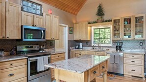 Una cocina amplia con armarios de madera, una isla grande y un microondas.