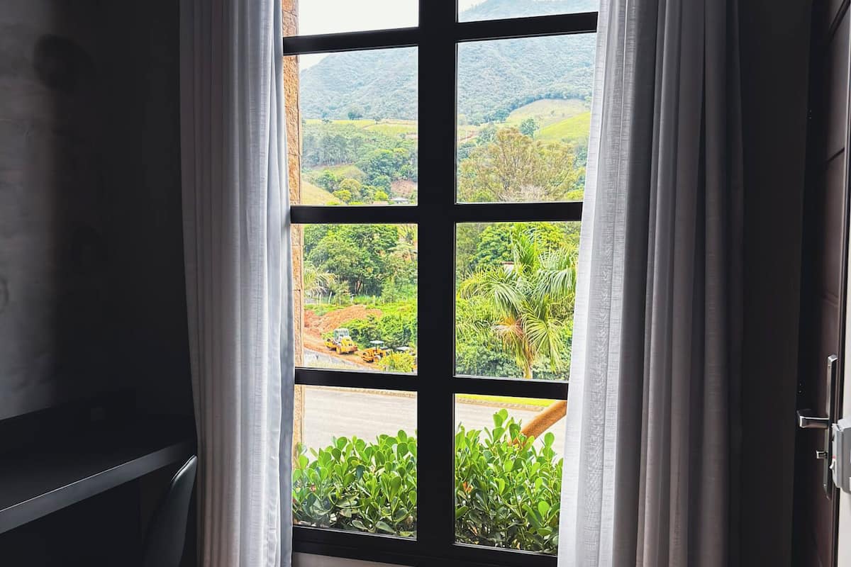 A room with a large window, a desk, and a chair.