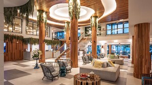 A spacious lobby with a checkered floor, wooden columns, a staircase, and seating areas. - Sandals Dunns River - All-inclusive Adults Only (Ocho Rios)