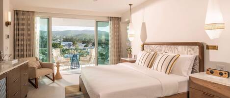 Habitación de hotel con una cama grande, un escritorio, una silla, un ventilador de techo y vistas al exterior.