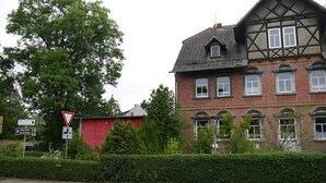 A traditional half-timbered house with a red brick facade and multiple windows.