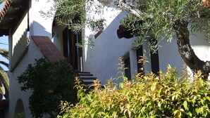 A building with a white facade, red-tiled roof, and a staircase leading to an entrance. - Experience San Clemente's Historic Charm in Our Beautifully Furnished Studio (San Clemente)