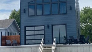 A modern two-story building with a large garage door and a staircase leading to the entrance.