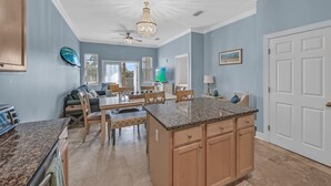 Une cuisine spacieuse dotée de plans de travail en granit, d’armoires en bois et d’un îlot central.