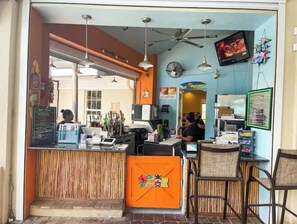 Ein Restaurantinneres mit Theke, Sitzbereich und Deckenventilator.