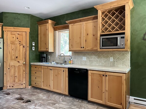 A kitchen with wooden cabinets, a microwave, and a dishwasher.