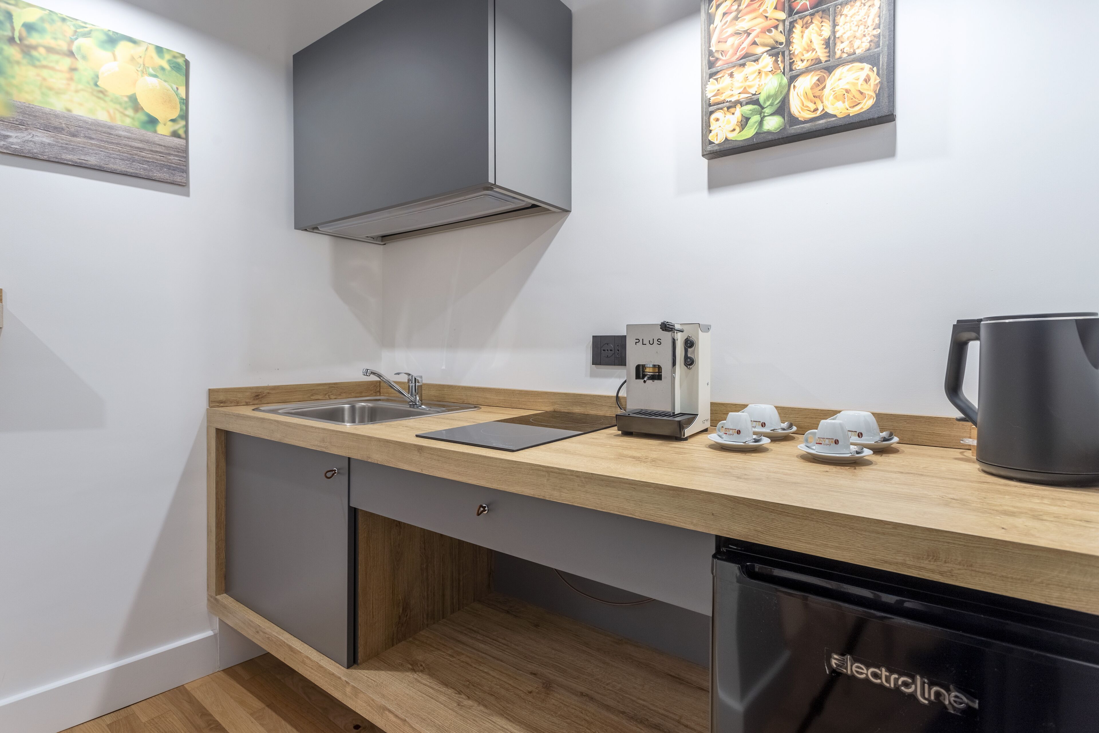 Una cocina moderna con encimera de madera, lavaplatos de acero inoxidable y lavavajillas integrado.
