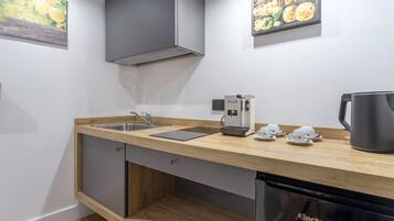 Una cocina moderna con encimera de madera, lavaplatos de acero inoxidable y lavavajillas integrado.