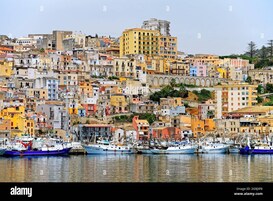Una cittadina costiera con edifici colorati e barche ormeggiate nel porto.