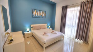 A bedroom with a bed, bedside tables, a lamp, and a window with curtains. - Tastefully furnished 3beds/3baths, 2balconies WVID1 (Gzira)