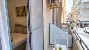 A balcony with a bed, a table with a glass of orange juice, and a potted plant. - Tastefully furnished 3beds/3baths, 2balconies WVID1 (Gzira)