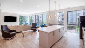 A modern living room with a sofa, chairs, a coffee table, and a kitchen island. - Chic 1 bed Apt + Rooftop & Gym - Downtown Stamford (Stamford)