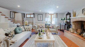 A living room with a sofa, coffee table, fireplace, and a staircase. - Villa Arsina in Lucca (Lucca)
