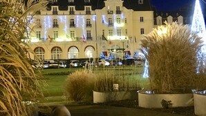 Um hotel com arquitetura europeia clássica, apresentando uma fachada simétrica com várias janelas e uma entrada central.