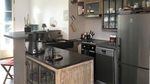 Uma cozinha moderna com uma ilha central, eletrodomésticos de aço inoxidável e armários de madeira.