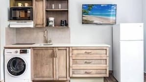 Cocina compacta con lavadora, microondas, lavabo y refrigerador.