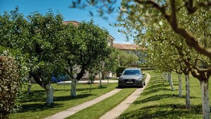 Un sendero bordeado de árboles que lleva a un edificio de techo rojo.