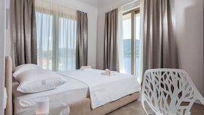 Une chambre à coucher avec un lit, une chaise et une vue sur l’extérieur.