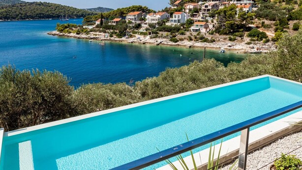 Une piscine offrant une vue dégagée sur une ville côtière et la mer.