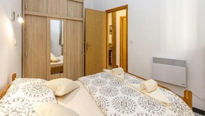 A bedroom with a bed, a wardrobe, and a radiator. - Apartment Senj - Two Bedroom Apartment (Senj)