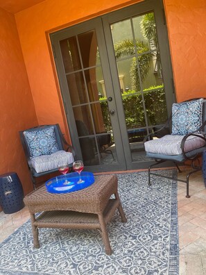 Relax in this serene outdoor seating area with two comfortable chairs and a stylish ottoman.