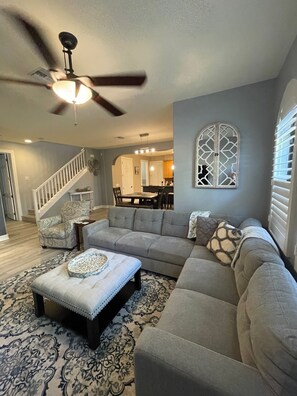 Relax in this inviting living room with a large sofa, ottoman, and area rug.
