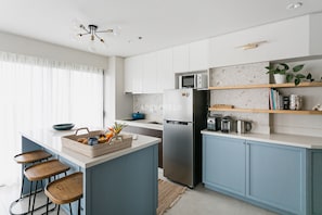 Enjoy cooking in this kitchen with a central island, microwave, and stainless steel refrigerator.