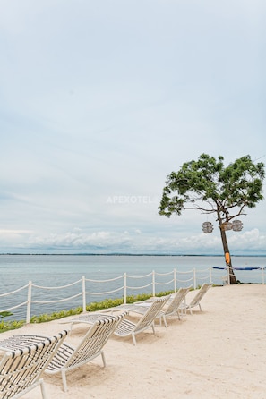 Relax on the beach with comfortable lounge chairs and enjoy the tranquil sea views.