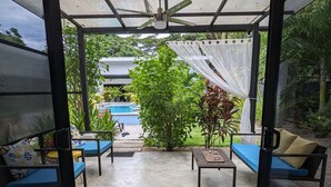 An open patio with a ceiling fan, a pool, and outdoor seating. - Coconut Life Cabinas "Rockford" -  One Bedroom, Close to Store, Town and Beach (Sámara)