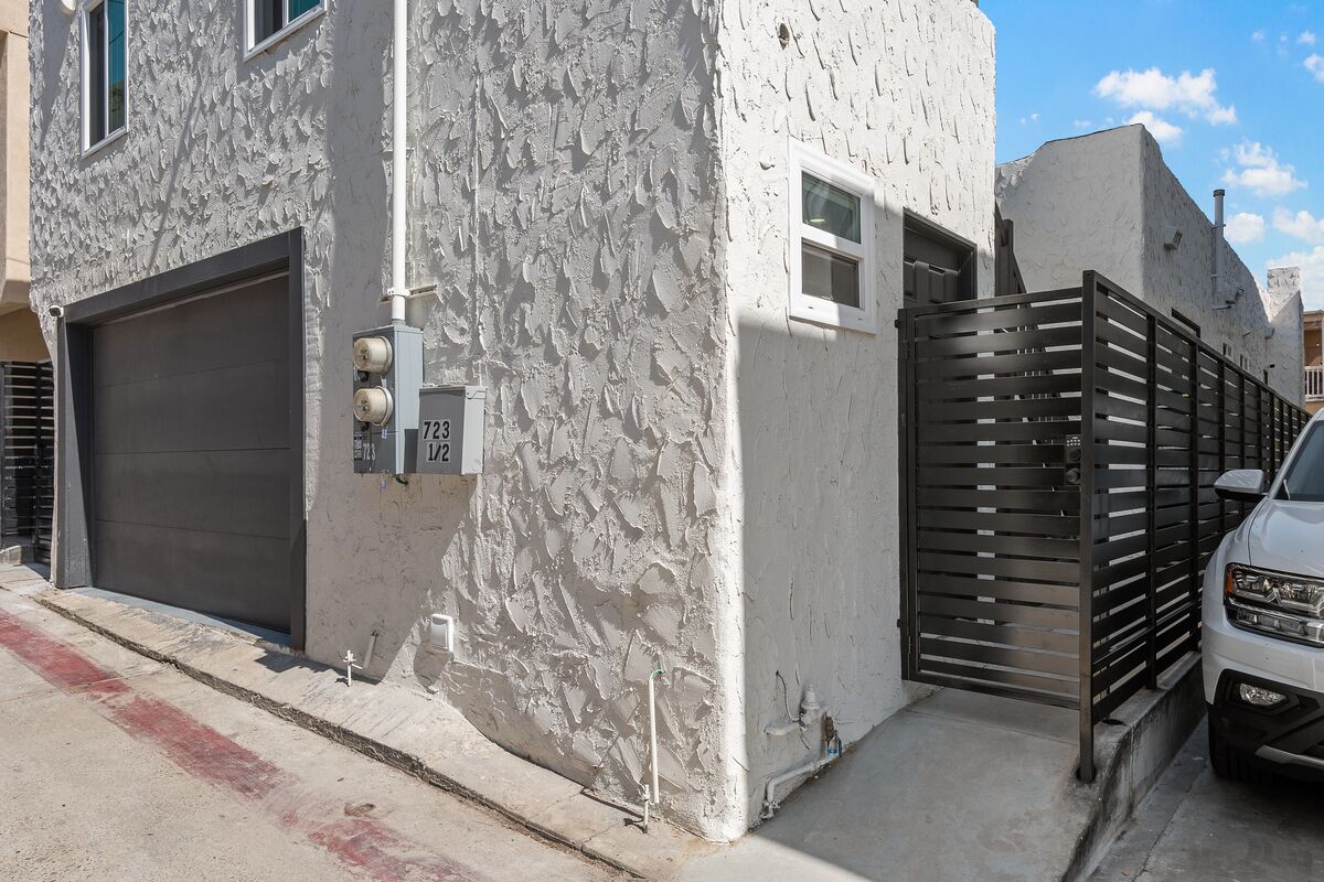 A building with a textured facade, a garage door, and a gated entrance.