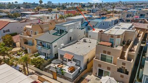 A residential area with multiple two-story houses, some with balconies and a few with visible outdoor seating areas. - Modern Retreat Steps to the Beach! (San Diego)